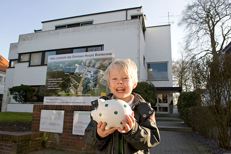 Ein kleiner Junge hält ein Sparschwein